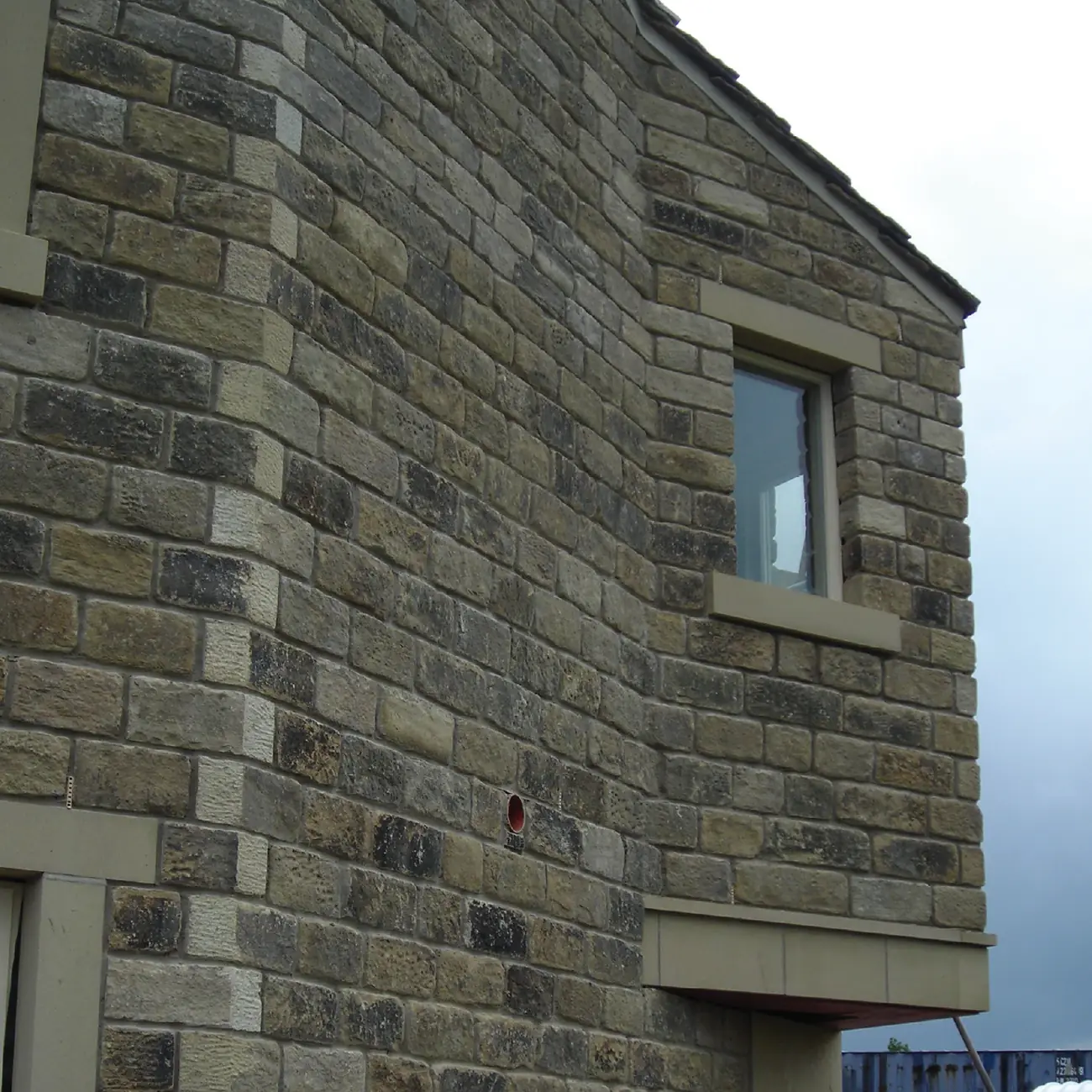 Coursed stone gable with a new window opening and dressed surround