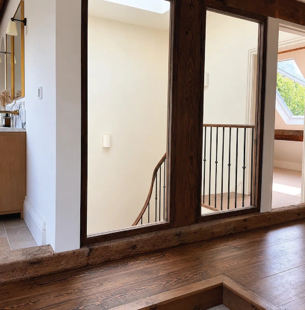 Reclaimed oak beam and full-height mirror on a remodelled landing