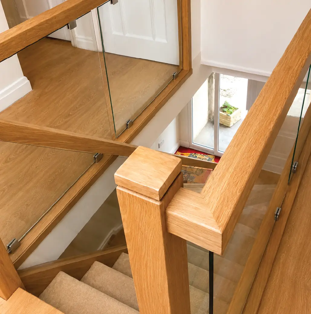 Oak handrail and frameless glass balustrade to a galleried landing